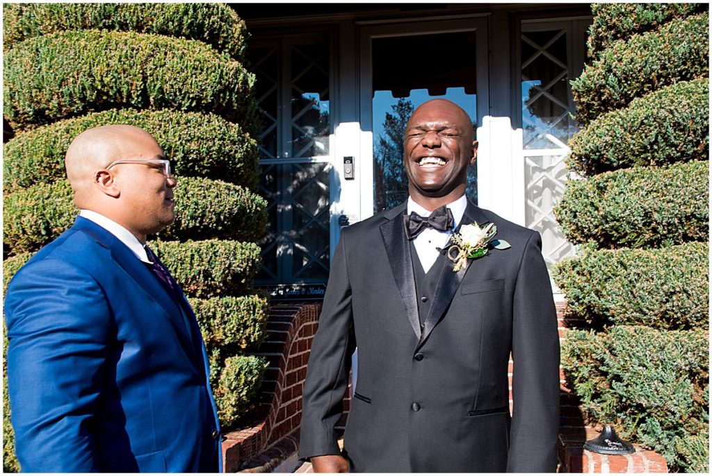 Groom laughs with one of his friends outside the groom suite at the Historic Mankin Mansion
