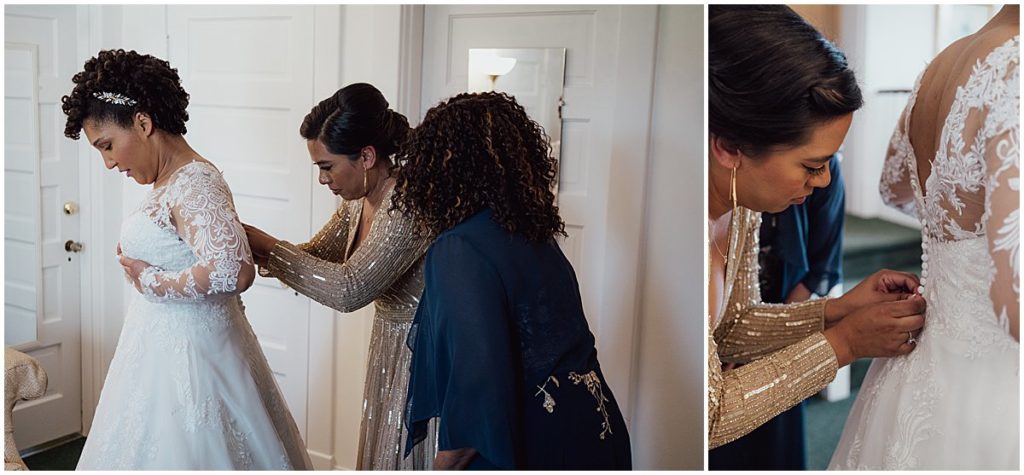 Matron of honor and bride's mother help her into her wedding dress