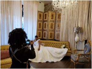 DC wedding photographer from Class & Style Productions, takes a photo of a bride on a decorative sofa.